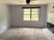 Living room featuring gray carpet, a fireplace, and a large window at 305 Anderson Cir, Covington, GA 30016