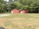 Exterior shot of two red storage buildings in a grassy backyard at 305 Anderson Cir, Covington, GA 30016