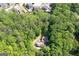 Aerial view of a secluded home enveloped in trees and with neighborhood properties visible in the distance at 465 Willowbrook Dr, Smyrna, GA 30082