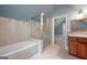 Bright bathroom featuring a tub, glass-enclosed shower, tiled walls, and a wooden vanity at 465 Willowbrook Dr, Smyrna, GA 30082