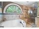 Close-up of a soaking tub and glass shower, with a window view and detailed tile work at 465 Willowbrook Dr, Smyrna, GA 30082