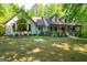 Charming home with covered porch, American flag, and mature trees set on a well-manicured lawn at 465 Willowbrook Dr, Smyrna, GA 30082