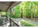 Inviting covered porch with swing and views of a wooded backyard, perfect for relaxing outdoors at 465 Willowbrook Dr, Smyrna, GA 30082