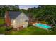 Beautiful backyard featuring a sparkling pool, lush green lawn, mature trees, and architectural design at 171 Ponderosa Drive, Fayetteville, GA 30214