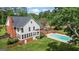 Home exterior view of backyard featuring a swimming pool, lush green lawn, mature trees, and landscape design at 171 Ponderosa Drive, Fayetteville, GA 30214