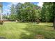Spacious backyard featuring mature trees, a gazebo, playground equipment and a well-maintained lawn at 171 Ponderosa Drive, Fayetteville, GA 30214