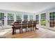 Bright dining area featuring hardwood floors, lots of windows, and a large rustic dining table with seating for six at 171 Ponderosa Drive, Fayetteville, GA 30214