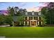 Elegant two-story brick home with a manicured lawn, black shutters, and dormer windows under a beautiful sunset sky at 171 Ponderosa Drive, Fayetteville, GA 30214