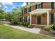 Inviting front entrance with a brick facade, black door, white trim, manicured lawn, and mature landscaping at 171 Ponderosa Drive, Fayetteville, GA 30214