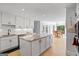 Modern kitchen with white cabinets, granite countertops, and stainless steel appliances open to dining area at 171 Ponderosa Drive, Fayetteville, GA 30214
