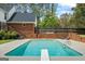 In-ground pool with diving board, patio area, and mature trees at 171 Ponderosa Drive, Fayetteville, GA 30214