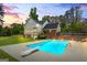 Backyard with in-ground pool, diving board, and patio area surrounded by manicured lawn and mature trees at 171 Ponderosa Drive, Fayetteville, GA 30214