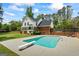 Backyard with in-ground pool, diving board, and patio area surrounded by manicured lawn and mature trees at 171 Ponderosa Drive, Fayetteville, GA 30214