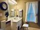 Bathroom with a white vanity, decorative mirror, stylish fixtures, and natural light from a window at 486 Village Cir, Stockbridge, GA 30281