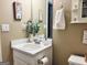 Bathroom with a white vanity, decorative mirror, and neutral-toned walls with decorative art at 486 Village Cir, Stockbridge, GA 30281