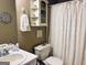Cozy bathroom featuring a decorative wall clock, corner cabinet, and a shower with a patterned curtain at 486 Village Cir, Stockbridge, GA 30281