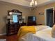 Cozy bedroom featuring a dresser, yellow throw, and hardwood floors at 486 Village Cir, Stockbridge, GA 30281