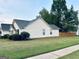 Side view of a well-maintained home with a green lawn and mature trees at 486 Village Cir, Stockbridge, GA 30281