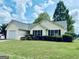 Charming one-story home with a well-manicured lawn and vibrant landscaping at 486 Village Cir, Stockbridge, GA 30281