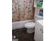 Compact bathroom featuring floral shower curtain, toilet, and vanity at 1071 Ponderosa Park Dr, Forest Park, GA 30297