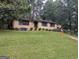 Lovely brick home with a well-maintained lawn, mature trees and driveway at 1071 Ponderosa Park Dr, Forest Park, GA 30297