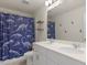 Well-lit bathroom features double sinks and a playful dinosaur-themed shower curtain at 168 Warbler Way, Mcdonough, GA 30253