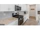 Modern kitchen features granite countertops, stainless steel microwave, and a gas range at 168 Warbler Way, Mcdonough, GA 30253