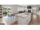 Open-concept kitchen with island seating, stainless steel appliances, and sliding glass doors to the backyard at 168 Warbler Way, Mcdonough, GA 30253