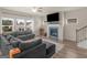 Spacious living room features a fireplace, large windows, modern ceiling fan and a gray sectional sofa at 168 Warbler Way, Mcdonough, GA 30253