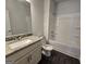 Well-lit bathroom with a granite countertop sink, a tub-shower combination, and plank flooring at 6120 Ripple Way # 46, South Fulton, GA 30349