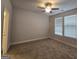 Bright bedroom with neutral carpet, ceiling fan, and natural light streaming through the window at 6120 Ripple Way # 46, South Fulton, GA 30349