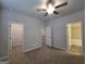 Spacious bedroom featuring neutral carpet, ceiling fan, walk-in closet, and an adjoining bathroom at 6120 Ripple Way # 46, South Fulton, GA 30349