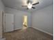Cozy bedroom with neutral carpet, ceiling fan, and access to a well-lit bathroom at 6120 Ripple Way # 46, South Fulton, GA 30349