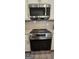 Stainless steel appliances including GE range/oven, microwave, and grey tile backsplash at 6120 Ripple Way # 46, South Fulton, GA 30349