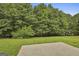 View of backyard featuring a well-maintained lawn, trees and a concrete slab at 122 Claxton Ct, Jonesboro, GA 30238