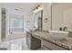 Bright bathroom featuring dual vessel sinks, granite countertops, soaking tub, and marble tile at 122 Claxton Ct, Jonesboro, GA 30238