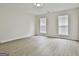 Empty bedroom featuring two windows, neutral walls, and wood-look floors at 122 Claxton Ct, Jonesboro, GA 30238