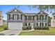 Charming two-story home featuring a stone facade, gray siding, black shutters and a well-manicured lawn at 122 Claxton Ct, Jonesboro, GA 30238