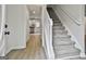 A bright foyer with hardwood floors, stairs, white railings, and a view into the kitchen at 122 Claxton Ct, Jonesboro, GA 30238