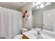 Bright bathroom features a toilet, vanity, sink, and a shower with white curtain at 7115 Secret Rose, Douglasville, GA 30134