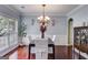 Elegant dining room with a decorative chandelier, wainscoting, and rich hardwood floors at 7115 Secret Rose, Douglasville, GA 30134