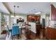 Open-concept kitchen and dining area with modern appliances, an island with seating, and wood floors at 7115 Secret Rose, Douglasville, GA 30134