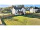 Wide-angle view of a house featuring a fenced backyard, verdant lawn, and a deck with wooden stairs at 5284 Benjamin Trl, Ellenwood, GA 30294