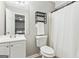 This bathroom with white fixtures boasts ample storage space and a shower with white curtain at 5284 Benjamin Trl, Ellenwood, GA 30294