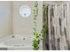 Modern bathroom features a soaking tub with decorative shower curtain and octagon window at 5284 Benjamin Trl, Ellenwood, GA 30294