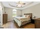 A serene bedroom with a wooden bed frame, ceiling fan, and ample natural light at 5284 Benjamin Trl, Ellenwood, GA 30294
