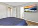 This bedroom is equipped with a TV, wood flooring, neutral-toned walls, and an ensuite bathroom entrance at 5284 Benjamin Trl, Ellenwood, GA 30294