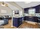 Open kitchen showcasing dark blue cabinets, stainless appliances, and island with seating, plus vaulted ceilings at 5284 Benjamin Trl, Ellenwood, GA 30294