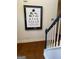 Staircase showing hardwood floors and a framed art print, featuring an eye chart, hanging on the wall at 232 Spalding Gates Drive, Atlanta, GA 30328