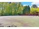 A community tennis court surrounded by tall green trees on a sunny day at 232 Spalding Gates Drive, Atlanta, GA 30328